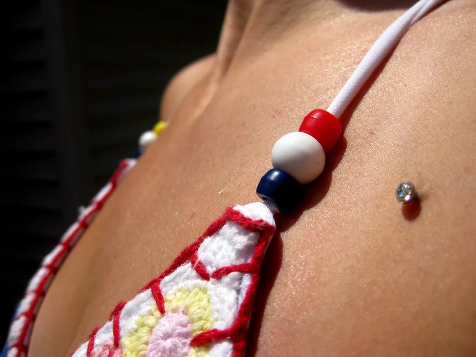 Single dermal anchor stud on the upper chest — reference photo