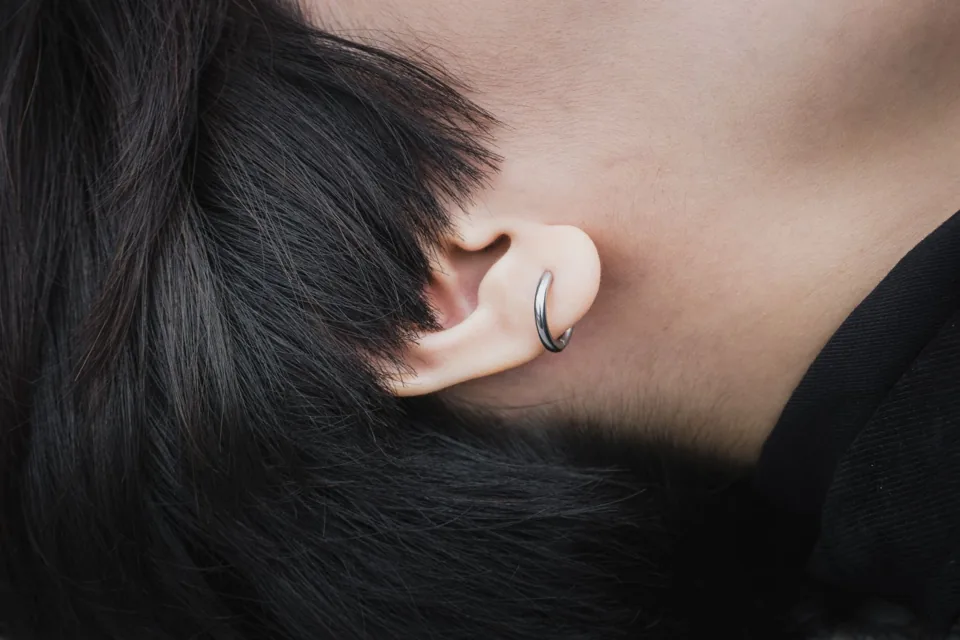 Silver hoop through an earlobe — reference photo