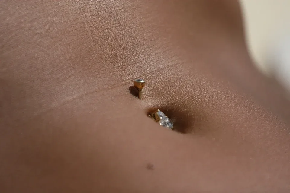 Jewellery through the upper rim of the belly button — reference photo