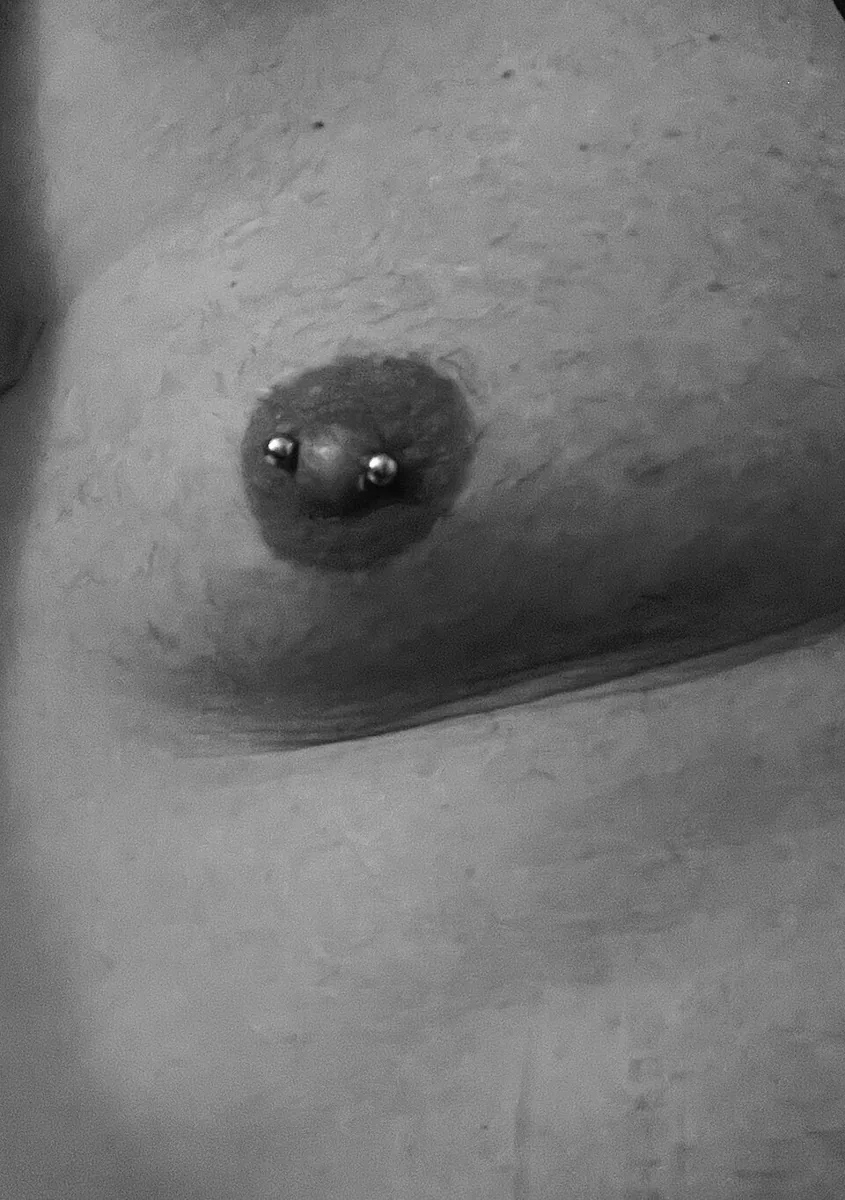 Close-up of barbell jewellery through a nipple — reference photo