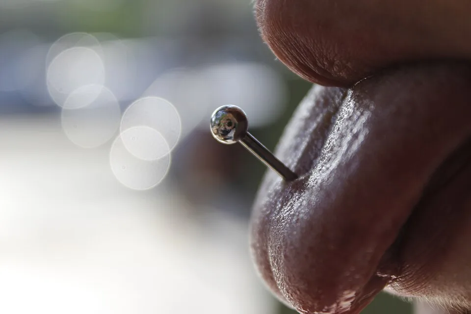 Close-up of a silver tongue barbell — reference photo